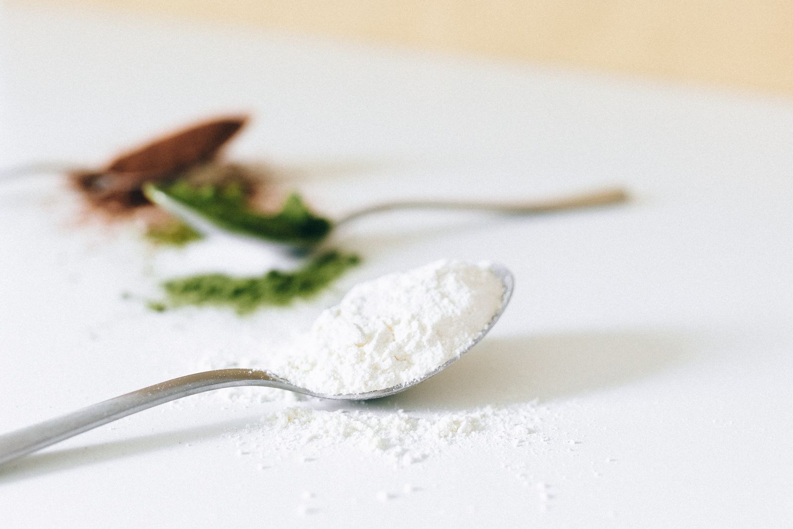Silver spoon heaped with fine white collagen powder