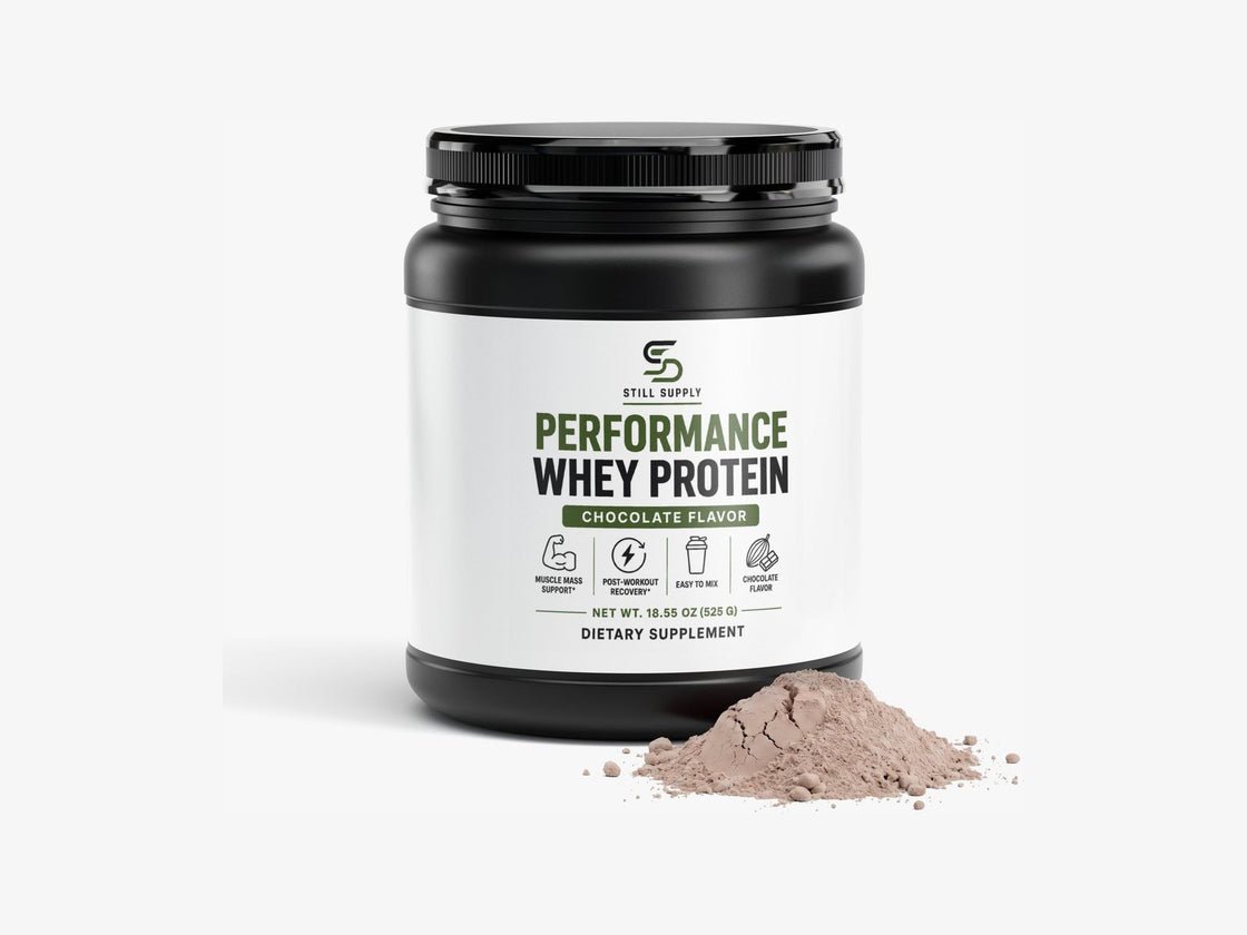Still Supply Performance Whey Protein tub in chocolate with a pile of powder